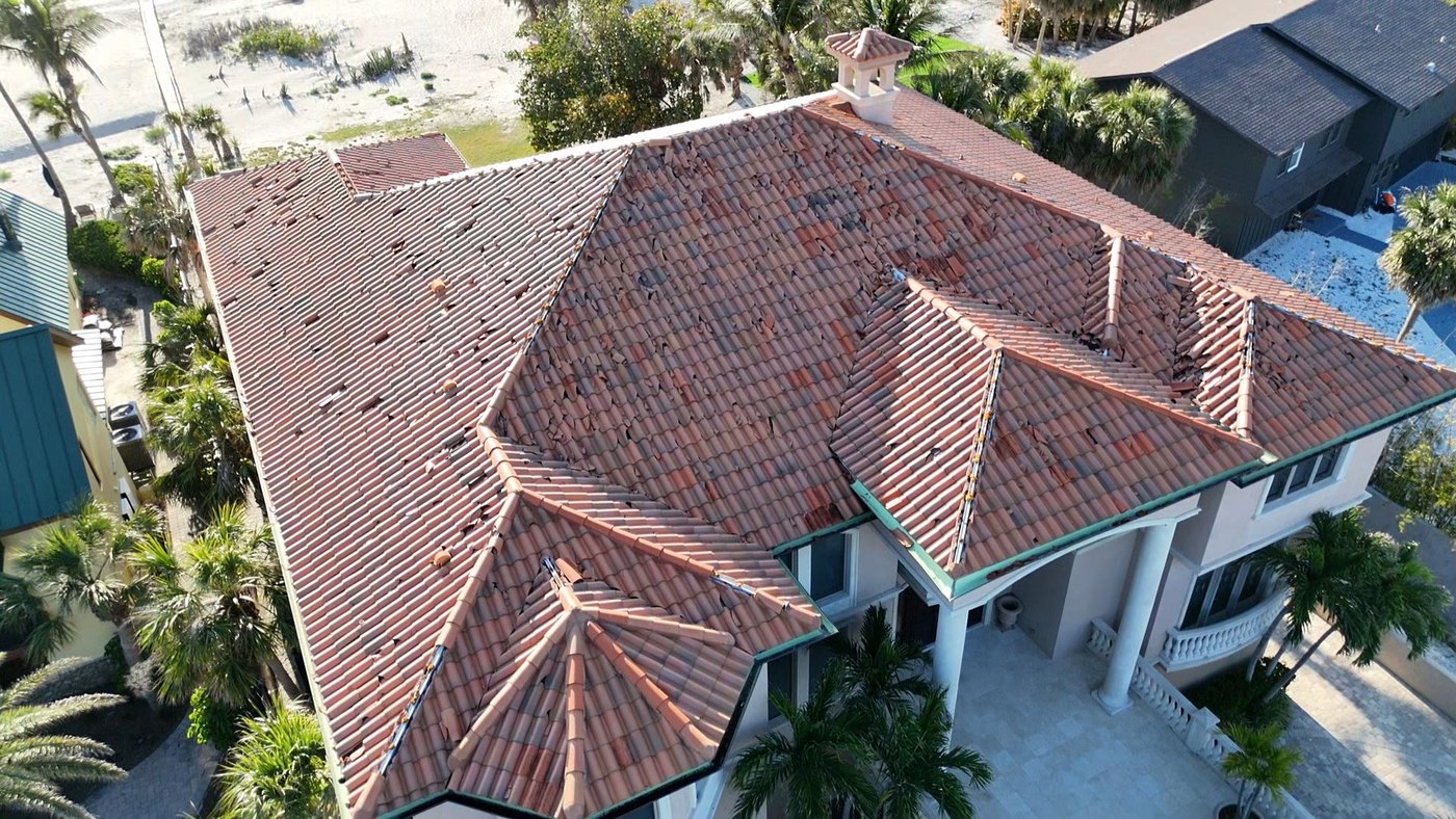Before: storm-damaged Florida barrel tile roof with missing and broken tiles
